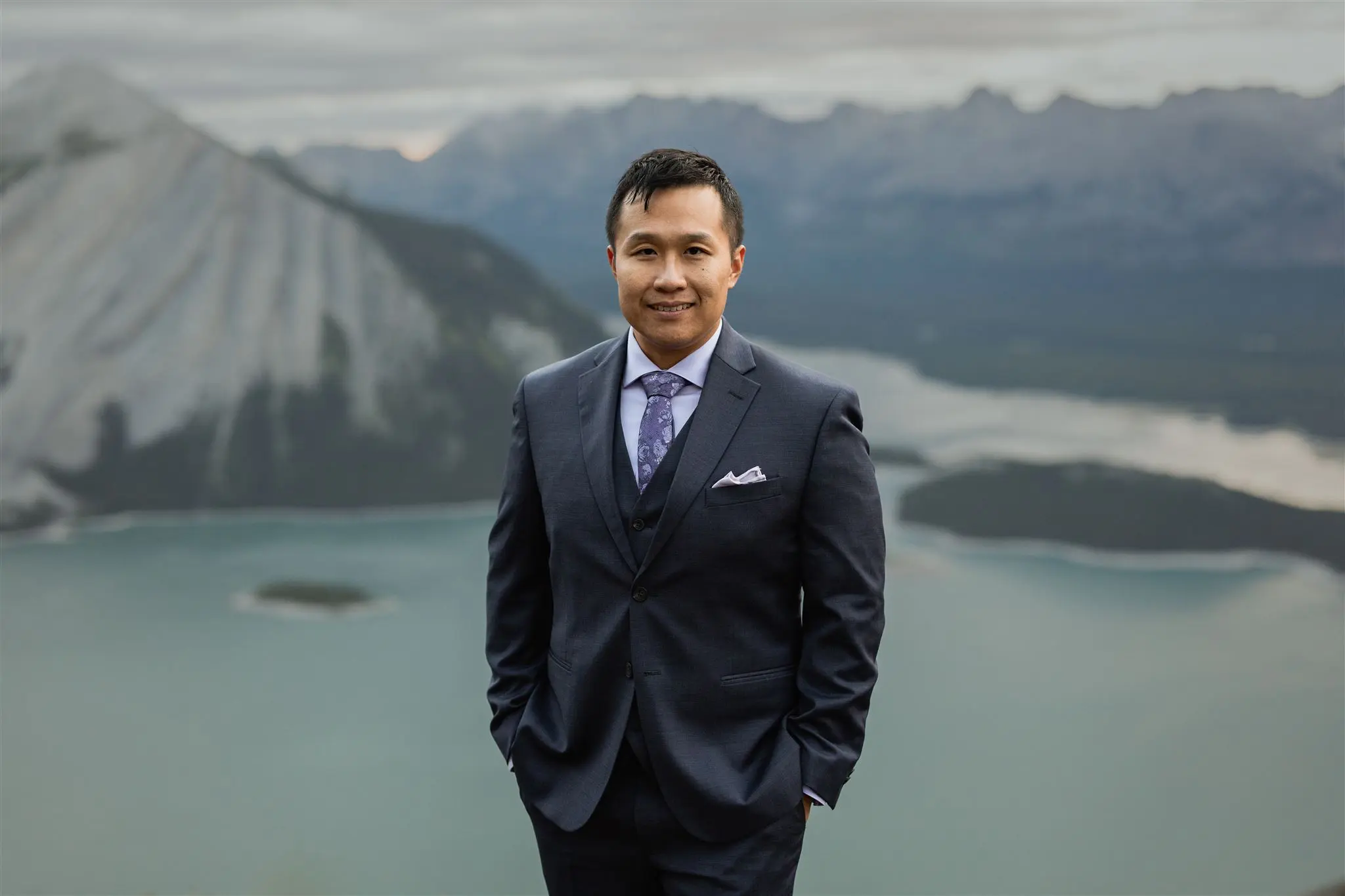 Alex Leung on a scenic mountain overlook, enjoying the outdoors and mountain views during a hiking adventure