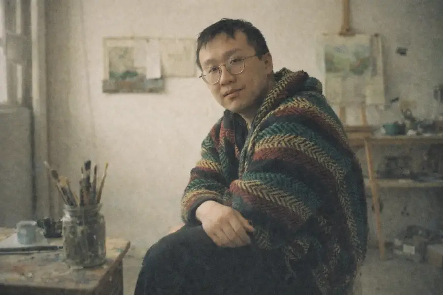 Alex Leung sitting in an art studio