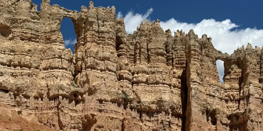 Bryce Canyon hoodoo wall with natural openings under a blue sky
